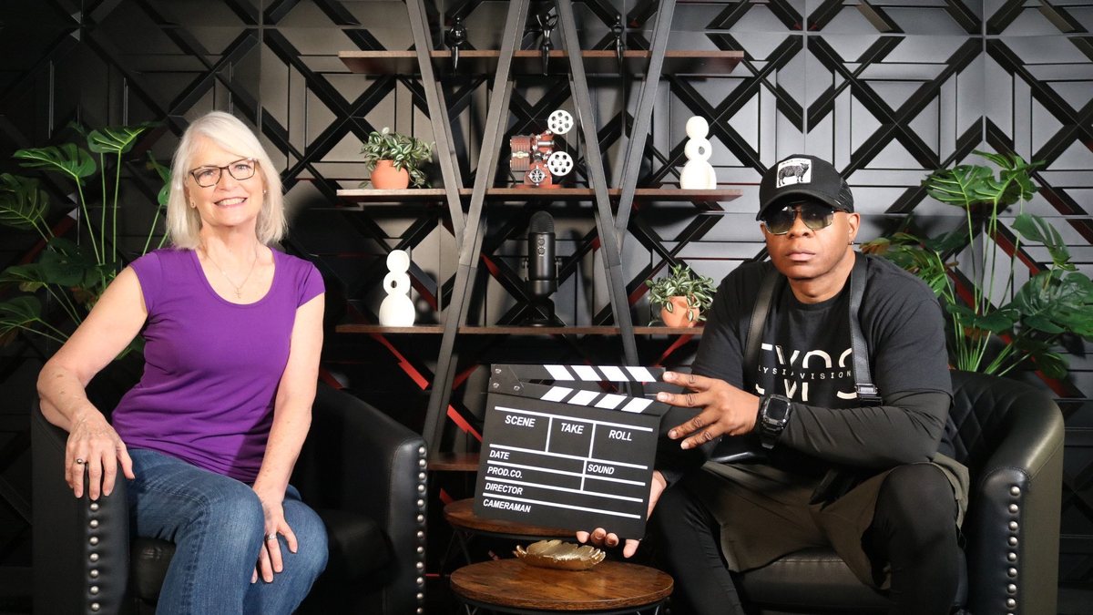 CK Worley on the podcast set with a clapperboard